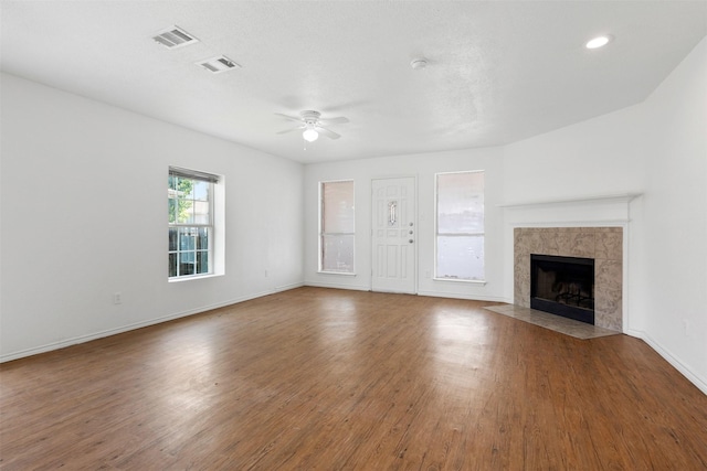 8109 Dripping Springs Dr, Fort Worth, TX 76134 - unfurnished living room with ceiling fan, a tile fireplace, wood finished floors, and baseboards
