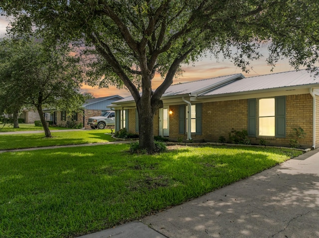 108 Mockingbird Ln, Hillsboro, TX 76645 - view of front of house featuring brick siding, a front lawn, and metal roof