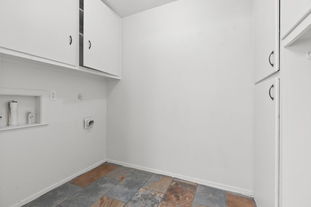 108 Mockingbird Ln, Hillsboro, TX 76645 - laundry area with cabinet space, electric dryer hookup, baseboards, and stone tile floors
