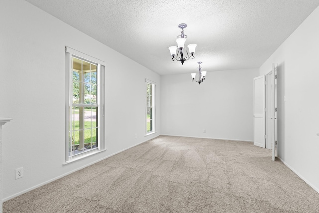 108 Mockingbird Ln, Hillsboro, TX 76645 - spare room featuring a chandelier, carpet, a textured ceiling, and baseboards