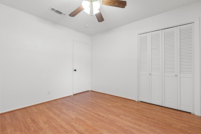 108 Mockingbird Ln, Hillsboro, TX 76645 - unfurnished bedroom featuring light wood finished floors, ceiling fan, a closet, baseboards, and a textured ceiling