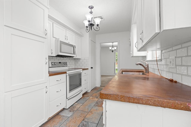 108 Mockingbird Ln, Hillsboro, TX 76645 - kitchen featuring white appliances, a sink, a chandelier, decorative backsplash, and white cabinets