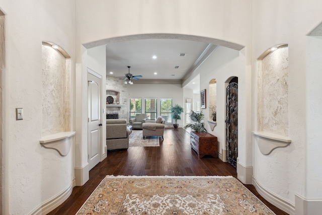 499 Savannah Hill Ln, Rockwall, TX 75032 - foyer featuring arched walkways, a ceiling fan, dark wood-type flooring, a fireplace, and recessed lighting