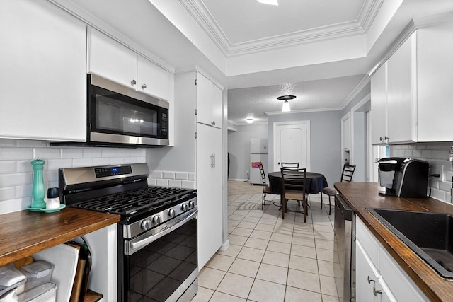2913 Harlan Dr, Mesquite, TX 75150 - kitchen with appliances with stainless steel finishes, light tile patterned flooring, tasteful backsplash, white cabinetry, and a sink