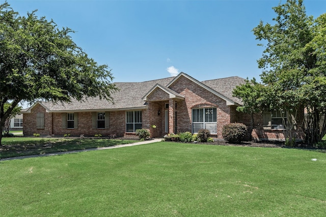 1301 Shell Beach Dr, Little Elm, TX 75068 - view of front of home with brick siding, a front yard, and a shingled roof