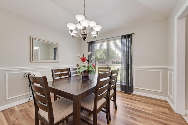 1301 Shell Beach Dr, Little Elm, TX 75068 - dining space featuring a chandelier, light wood-style floors, a decorative wall, and a wainscoted wall