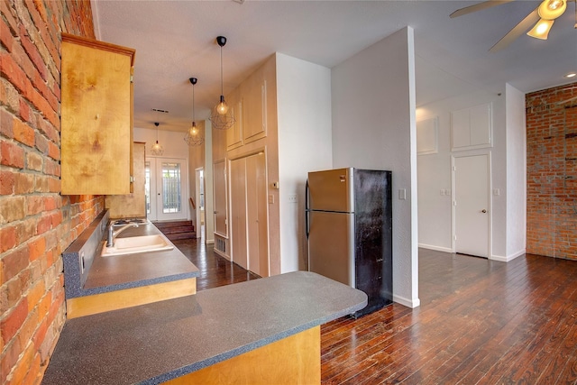 1213 Washington St Unit B, Commerce, TX 75428 - kitchen with a sink, freestanding refrigerator, dark wood finished floors, brick wall, and ceiling fan
