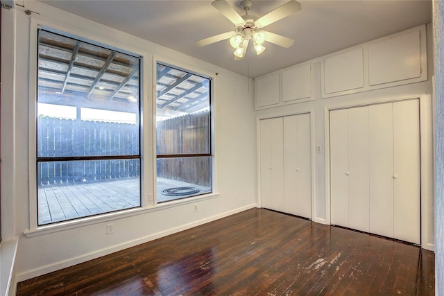 1213 Washington St Unit B, Commerce, TX 75428 - unfurnished bedroom with dark wood-type flooring, baseboards, and a ceiling fan