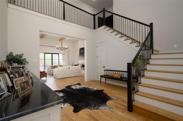 105 Shawnee Trl, Pottsboro, TX 75076 - living area featuring stairs, wood finished floors, a chandelier, and a towering ceiling