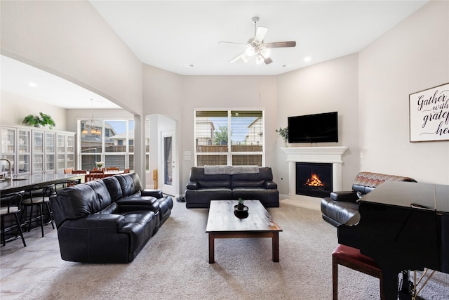 1211 Great Meadows Dr, Wylie, TX 75098 - living room with ceiling fan, a lit fireplace, arched walkways, carpet floors, and recessed lighting