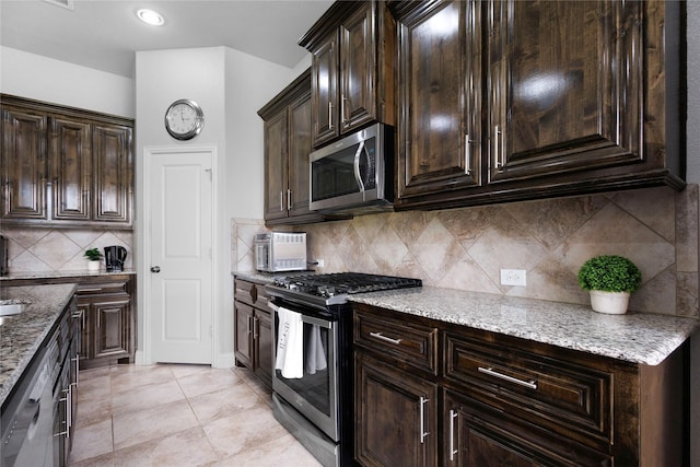 1211 Great Meadows Dr, Wylie, TX 75098 - kitchen with appliances with stainless steel finishes, light stone countertops, dark brown cabinetry, and backsplash
