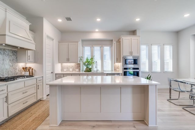 1721 Gem Dr, Rockwall, TX 75087 - kitchen featuring stainless steel appliances, custom exhaust hood, light countertops, plenty of natural light, and recessed lighting