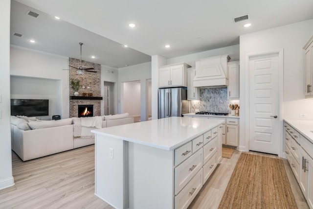 1721 Gem Dr, Rockwall, TX 75087 - kitchen featuring freestanding refrigerator, custom range hood, ceiling fan, gas stovetop, and tasteful backsplash