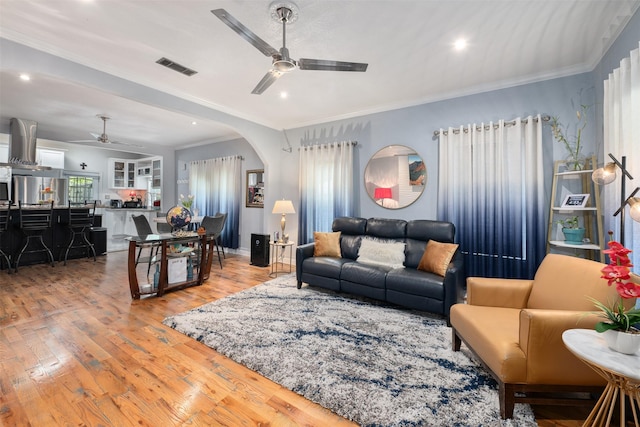 2832 Forest Ave, Fort Worth, TX 76112 - living room featuring ceiling fan, light wood-style floors, arched walkways, crown molding, and recessed lighting