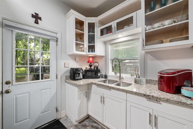 2832 Forest Ave, Fort Worth, TX 76112 - kitchen with a sink, white cabinets, light stone countertops, and black microwave