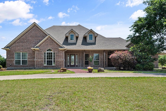 104 Spring Creek Dr, Waxahachie, TX 75165 - view of front of home with brick siding, a front lawn, and roof with shingles