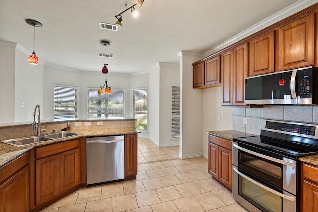 104 Spring Creek Dr, Waxahachie, TX 75165 - kitchen with stainless steel appliances, a sink, brown cabinets, tasteful backsplash, and plenty of natural light