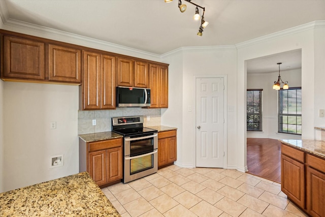 104 Spring Creek Dr, Waxahachie, TX 75165 - kitchen with stainless steel appliances, brown cabinets, a chandelier, and ornamental molding