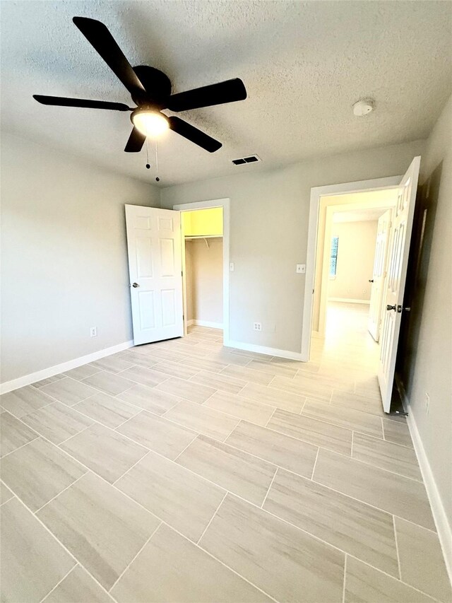 739 W Pine St, Jacksboro, TX 76458 - unfurnished bedroom featuring a textured ceiling, baseboards, a ceiling fan, and a closet