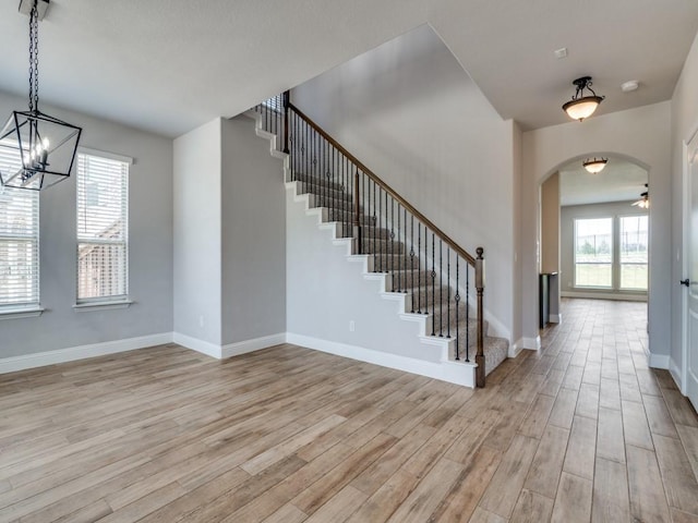 1517 Port Millstone Trl, Wylie, TX 75098 - foyer with light wood-style floors, stairway, arched walkways, baseboards, and a chandelier