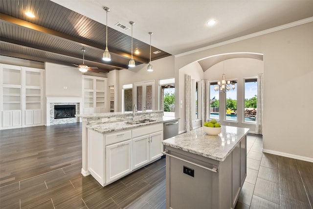 704 Prairie Timber Rd, Burleson, TX 76028 - kitchen with a sink, a kitchen island with sink, arched walkways, white cabinets, and stainless steel dishwasher