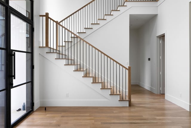 4207 Valley Ridge Rd, Dallas, TX 75220 - stairway featuring baseboards, wood finished floors, and a high ceiling