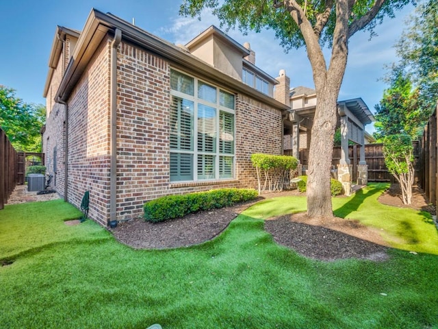 656 Clearwater Dr, Irving, TX 75039 - rear view of house featuring brick siding, central AC unit, and a chimney