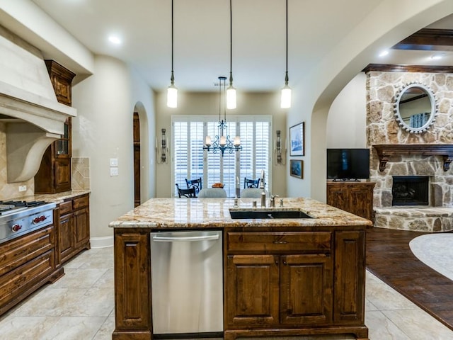 656 Clearwater Dr, Irving, TX 75039 - kitchen featuring stainless steel appliances, arched walkways, open floor plan, an island with sink, and light stone countertops