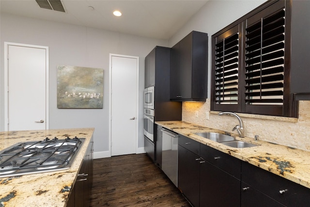 2411 N Hall St Unit 40, Dallas, TX 75204 - kitchen with appliances with stainless steel finishes, a sink, dark wood finished floors, dark cabinetry, and decorative backsplash