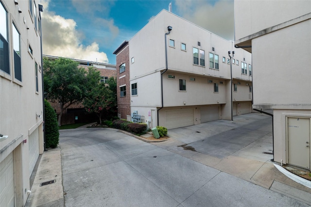 2411 N Hall St Unit 40, Dallas, TX 75204 - view of property exterior featuring an attached garage, stucco siding, and driveway