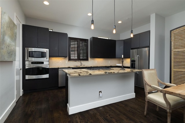 2411 N Hall St Unit 40, Dallas, TX 75204 - kitchen featuring appliances with stainless steel finishes, dark cabinetry, a sink, dark wood finished floors, and decorative backsplash