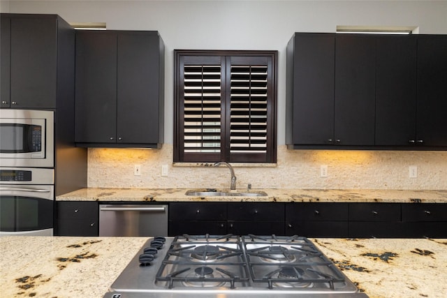 2411 N Hall St Unit 40, Dallas, TX 75204 - kitchen with appliances with stainless steel finishes, a sink, dark cabinets, backsplash, and light stone countertops
