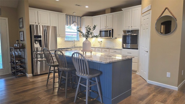 504 Greenwood Ln, Krum, TX 76249 - kitchen featuring stainless steel appliances, a sink, white cabinets, dark wood-type flooring, and recessed lighting