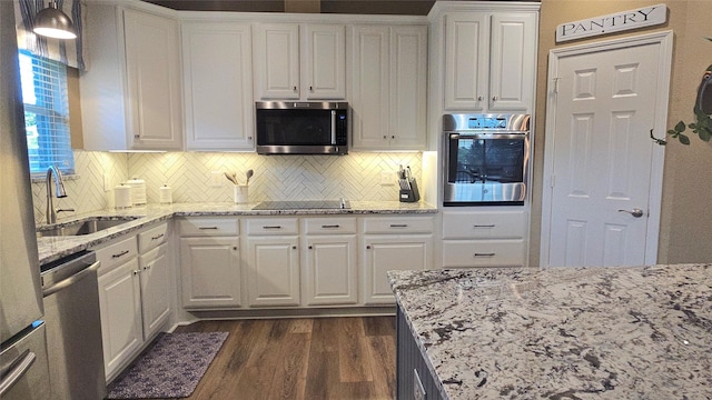 504 Greenwood Ln, Krum, TX 76249 - kitchen with stainless steel appliances, a sink, dark wood finished floors, and white cabinets