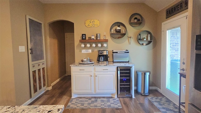 504 Greenwood Ln, Krum, TX 76249 - indoor dry bar with wine cooler, dark wood-style flooring, arched walkways, baseboards, and vaulted ceiling