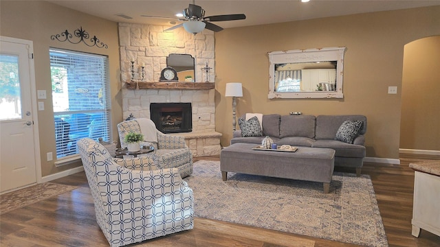 504 Greenwood Ln, Krum, TX 76249 - living area featuring ceiling fan, wood finished floors, a stone fireplace, and arched walkways
