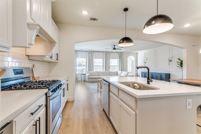 9825 Chaparral Pass, Fort Worth, TX 76126 - kitchen featuring stainless steel appliances, a sink, arched walkways, light wood-style flooring, and open floor plan