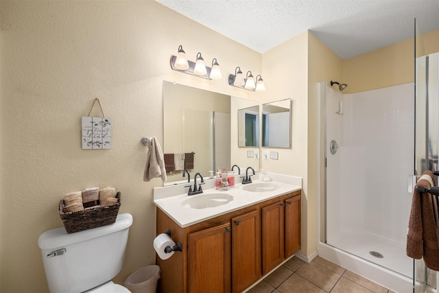 2104 Blanco Ln, Justin, TX 76247 - bathroom with toilet, tile patterned flooring, double vanity, a shower, and a textured ceiling