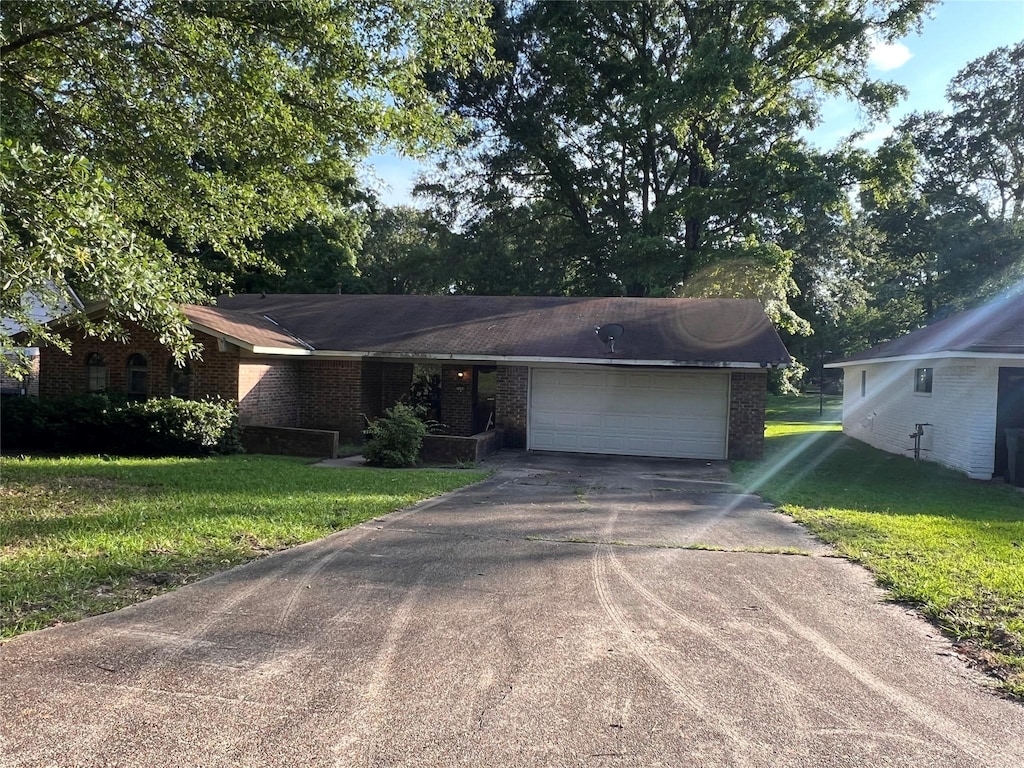 7204 Bobtail Cir, Shreveport, LA 71129 - view of front of home with brick siding, driveway, a front yard, and a garage