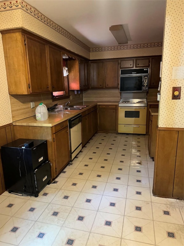 7204 Bobtail Cir, Shreveport, LA 71129 - kitchen with white appliances, light countertops, wallpapered walls, light tile patterned floors, and wooden walls