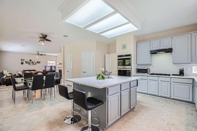 631 Ridgemont Dr, Allen, TX 75002 - kitchen with gray cabinets, appliances with stainless steel finishes, light countertops, a center island, and under cabinet range hood