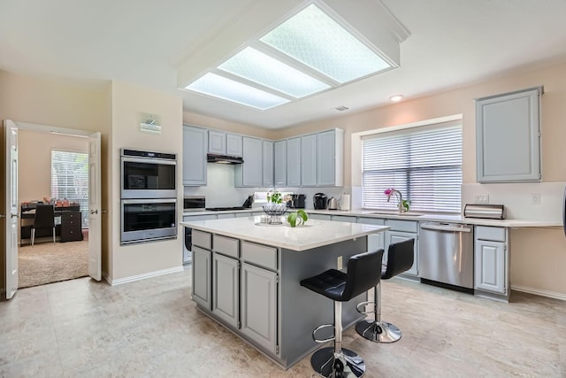 631 Ridgemont Dr, Allen, TX 75002 - kitchen featuring appliances with stainless steel finishes, a sink, light countertops, a kitchen island, and gray cabinets