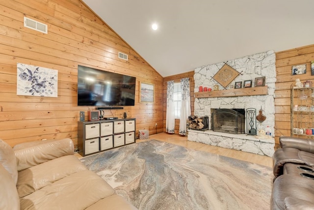 14213 Clark Dr, Streetman, TX 75859 - living room with wood walls, wood finished floors, a stone fireplace, and high vaulted ceiling