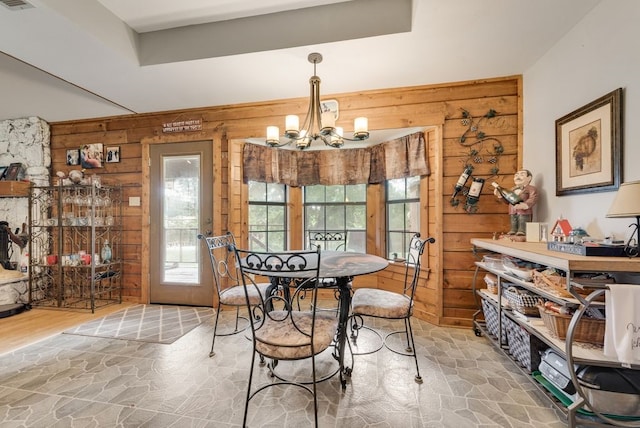 14213 Clark Dr, Streetman, TX 75859 - dining space featuring wooden walls, a chandelier, healthy amount of natural light, and stone finish flooring