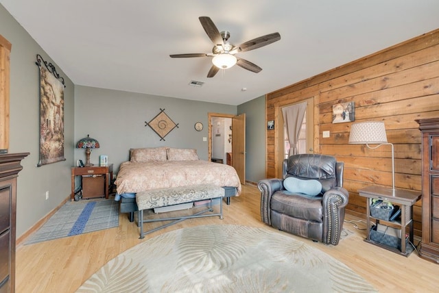 14213 Clark Dr, Streetman, TX 75859 - bedroom with light wood finished floors, wood walls, and ceiling fan