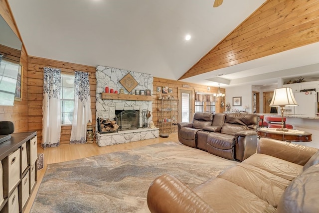 14213 Clark Dr, Streetman, TX 75859 - living room featuring wood walls, wood finished floors, high vaulted ceiling, recessed lighting, and a stone fireplace