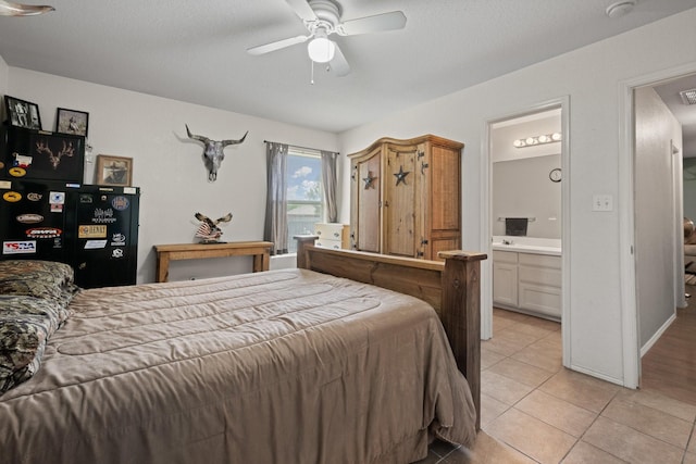 1105 Ashwood Ct, Cleburne, TX 76033 - bedroom featuring light tile patterned floors, connected bathroom, and ceiling fan