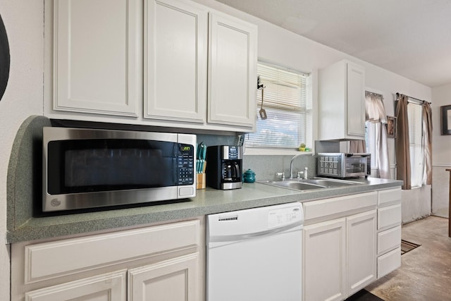 1105 Ashwood Ct, Cleburne, TX 76033 - kitchen with white dishwasher, stainless steel microwave, a sink, and white cabinetry