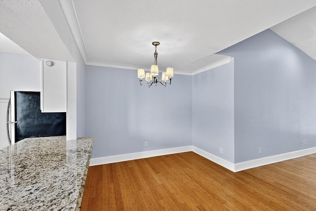 7736 Meadow Rd Unit 203, Dallas, TX 75230 - unfurnished dining area with a chandelier, wood finished floors, and ornamental molding