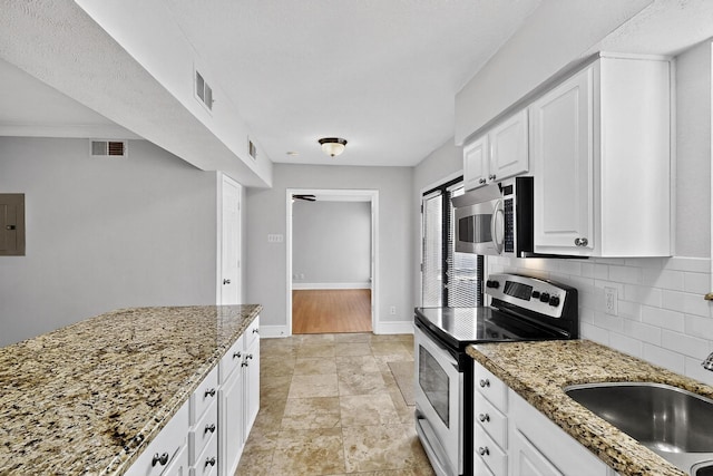7736 Meadow Rd Unit 203, Dallas, TX 75230 - kitchen featuring appliances with stainless steel finishes, backsplash, light stone countertops, white cabinetry, and electric panel
